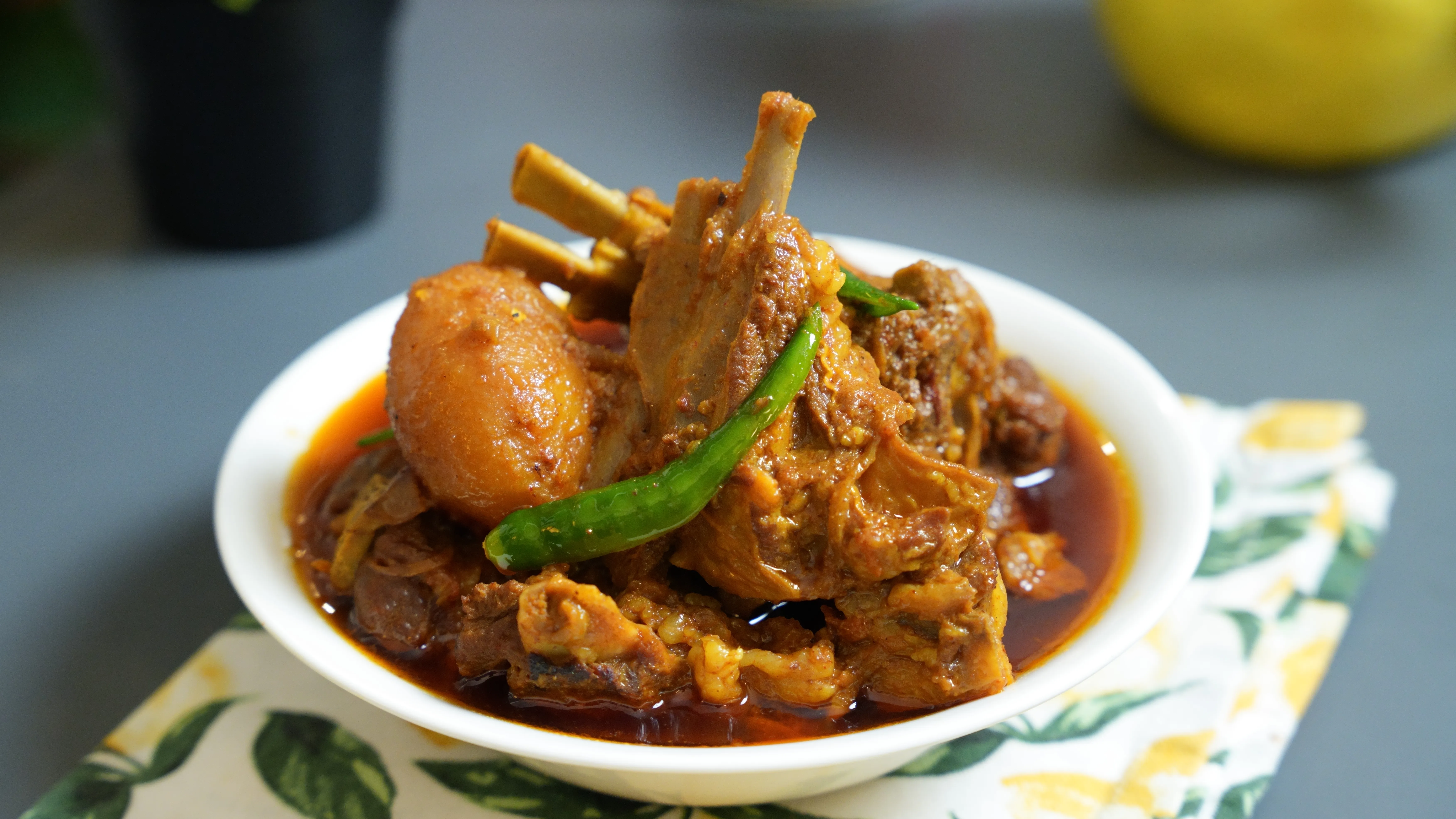 Bengali Sunday mutton curry with large mutton pieces and potatoes in a home-style gravy served with white rice.